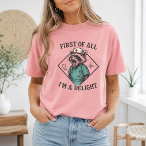 First Of All I'm A Delight Nurse Raccoon Graphic T-Shirt | Dusty Rose Funny Healthcare Cotton Tee
