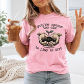 You're Never Too Old To Play In Dirt Gardening Graphic T-Shirt | Light Pink Botanical Cotton Tee