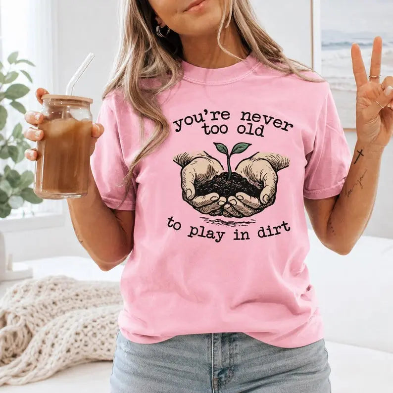 You're Never Too Old To Play In Dirt Gardening Graphic T-Shirt | Light Pink Botanical Cotton Tee